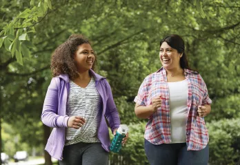 Two women walking outside and smiling