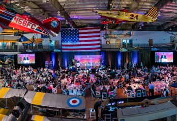 Ariel shot featuring the event venue, Frontiers of Flights Museum, event set up and attendees