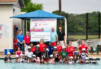 Reliant Energy with the YMCA staff and swim lesson participants with the $30,000 donation check
