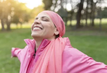 Istock photo- woman standing in the sunlight with arms open
