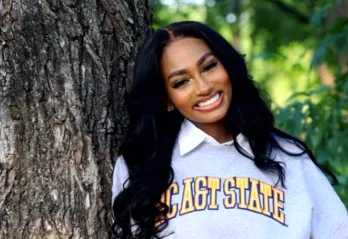 Alexis Williams posing in front of a tree