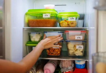 Hand in refrigerator with containers 