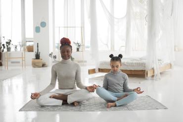 African American Woman and Kid Meditating Yoga
