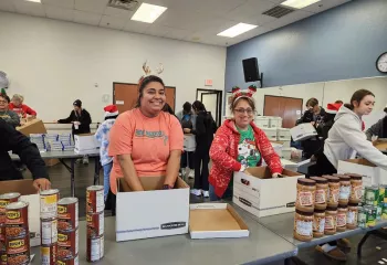 Two woman sorting food for Catalyst Christmas event
