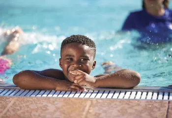 little boy smiling pool side