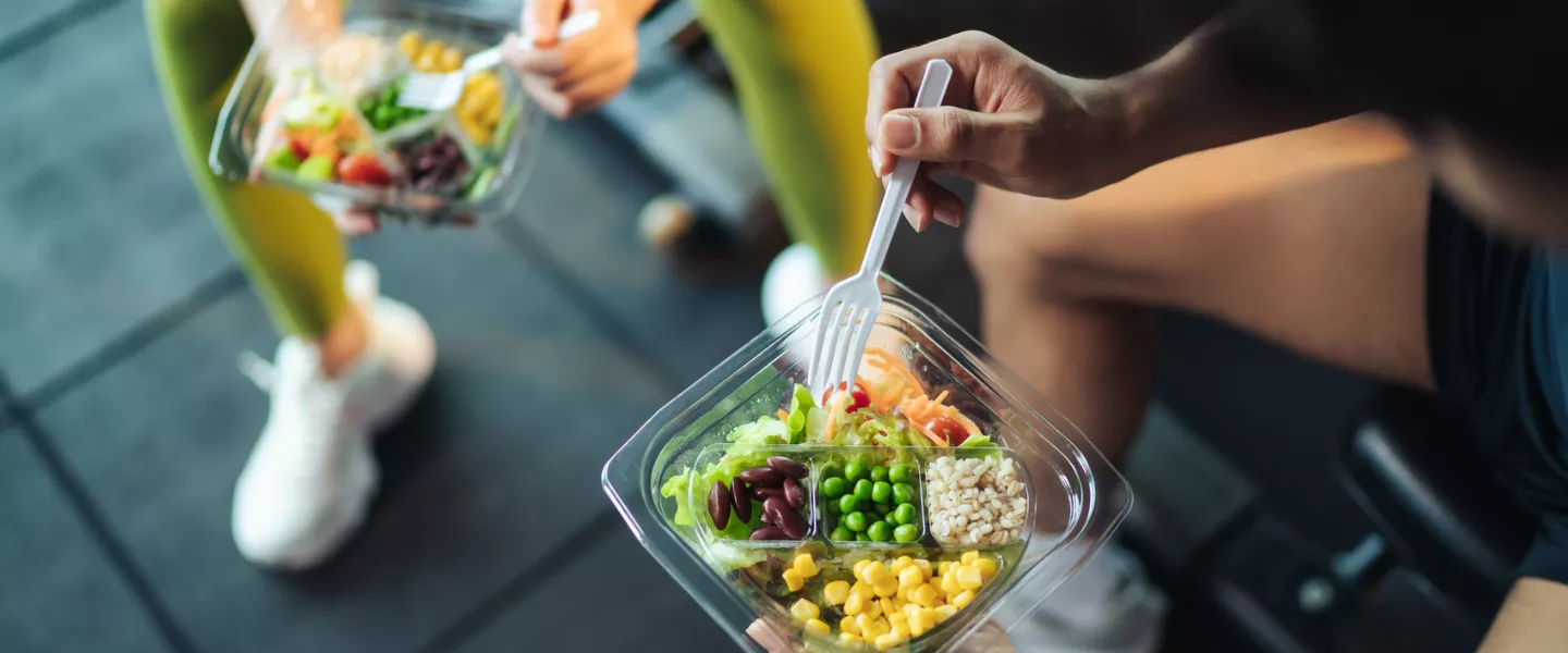 Two people eating a healthy meal in the gym