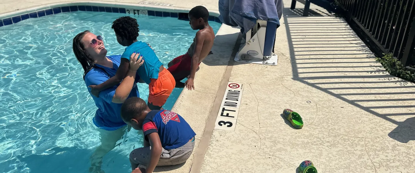 SAW shiloh village instructor smiling lifting child into pool