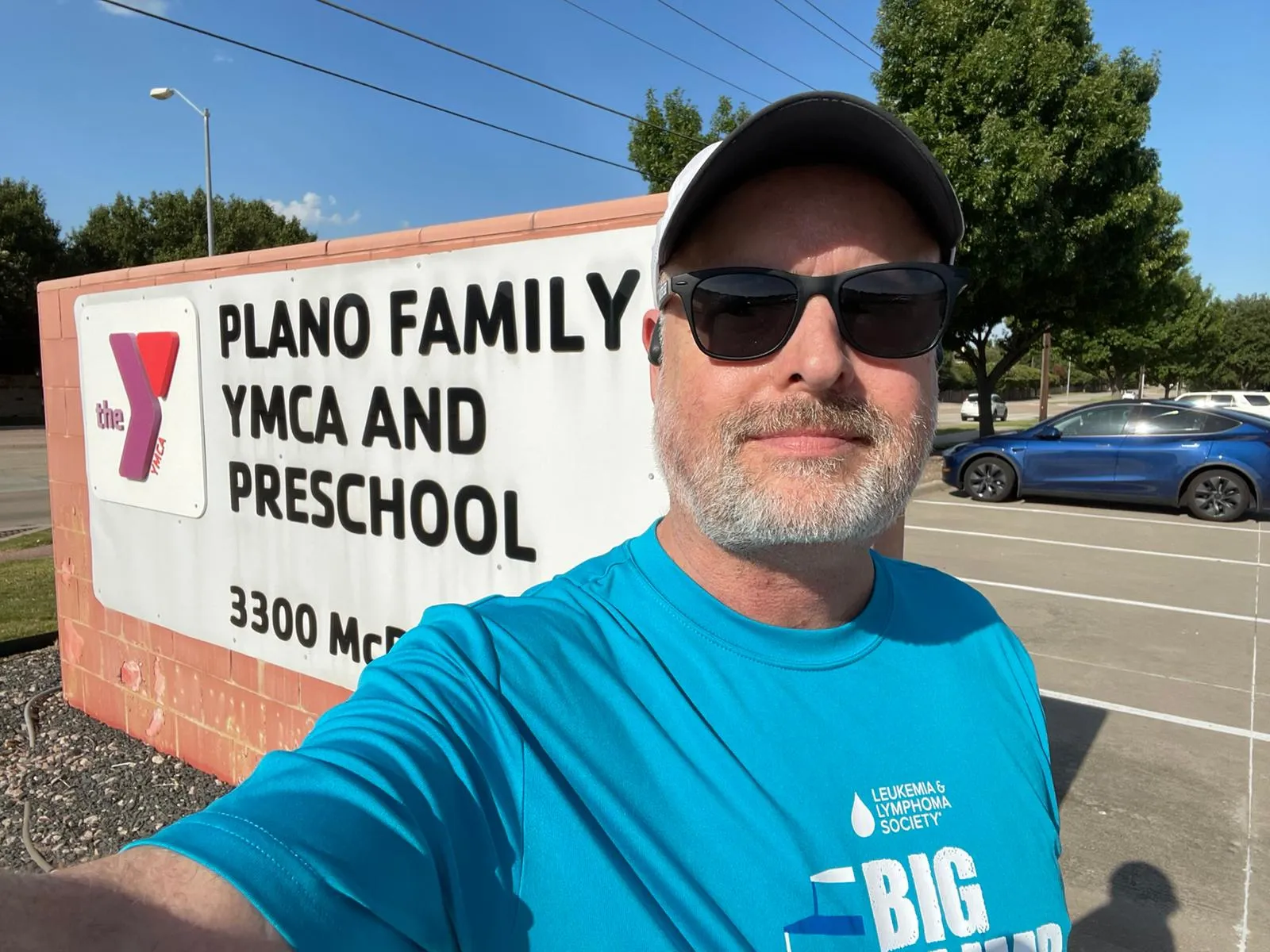 A selfie of Chris outside the Plano Family YMCA and Preschool sign