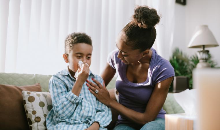 Mother Comforts Sick Child With Cold stock photo