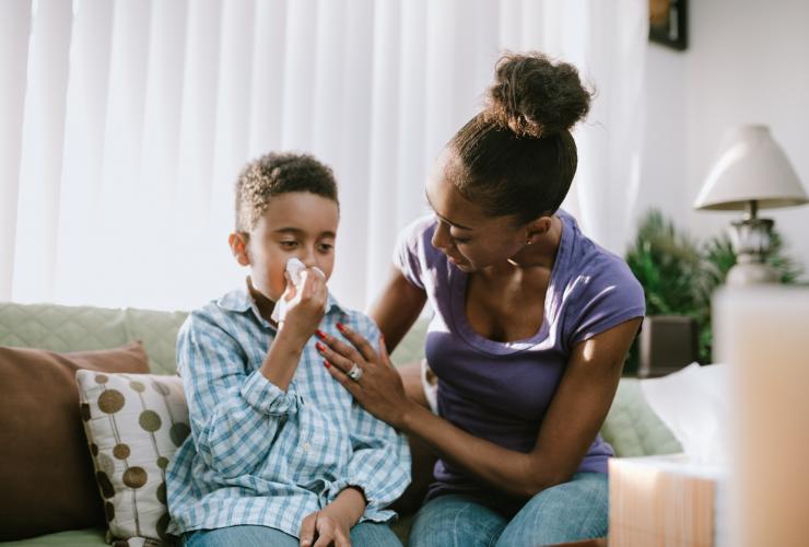 Mother Comforts Sick Child With Cold stock photo