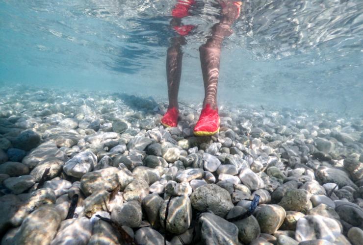 Young Adult Wearing Water Shoes for Walking at Rocky Shore stock photo