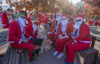 Group of people dressed as Santa with a dog