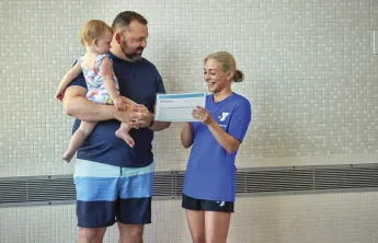 parent with child and swim instructor