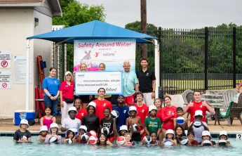 Reliant Energy with the YMCA staff and swim lesson participants with the $30,000 donation check