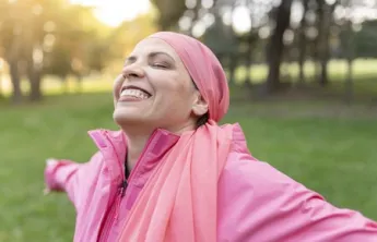 Istock photo- woman standing in the sunlight with arms open