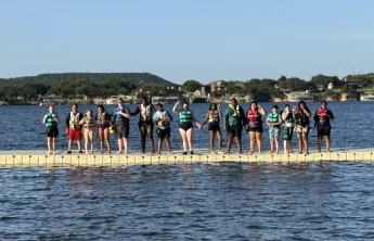 Kamp K'aana participants posing at deck for a photo