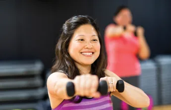 Lady holding weights during a group exercise class