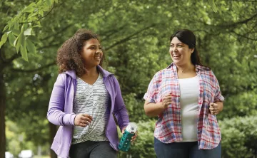 Two women walking outside and smiling