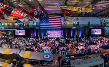 Ariel shot featuring the event venue, Frontiers of Flights Museum, event set up and attendees