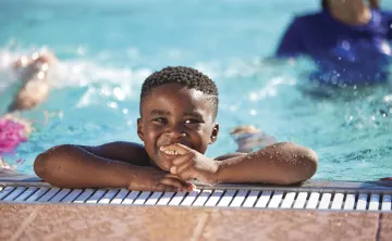 little boy smiling pool side