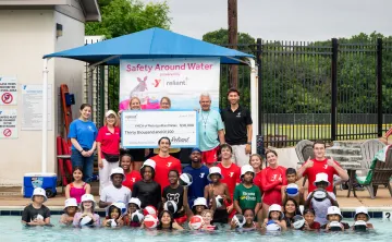 Reliant Energy with the YMCA staff and swim lesson participants with the $30,000 donation check