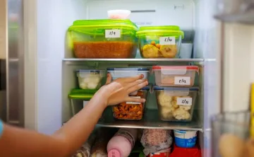 Hand in refrigerator with containers 
